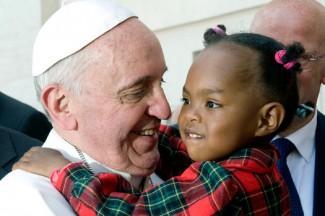 Pope Francis greets a child after celebrating Mass in St. Peter's Square. (CNS photo/Alessia Giuliani, Catholic Press Photo)