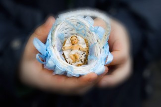 A boy holds a baby Jesus figurine in St. Peter's square. (CNS photo/Paul Haring)