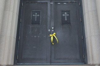 A yellow ribbon hangs from the doors of closed parish in Cleveland. (CNS photo/William Rieter)