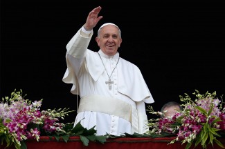 Pope Francis greets the crowd as he arrives to deliver his Easter message and blessing from the central balcony of St. Peter's Basilica. (CNS photo/Paul Haring)