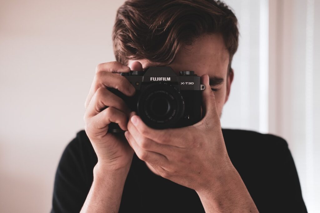 A man looking through a camera lens.