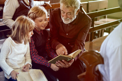 priest talks with children at church