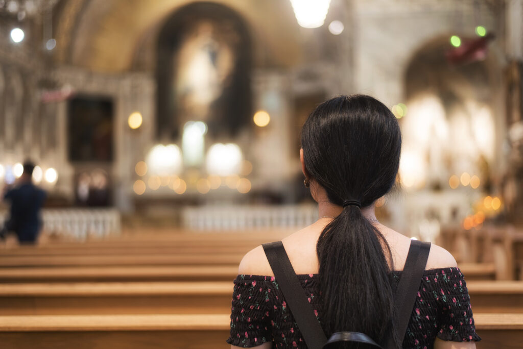 Image of the back of a young woman sitting in church