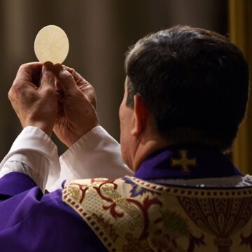 Priest holds up communion wafer