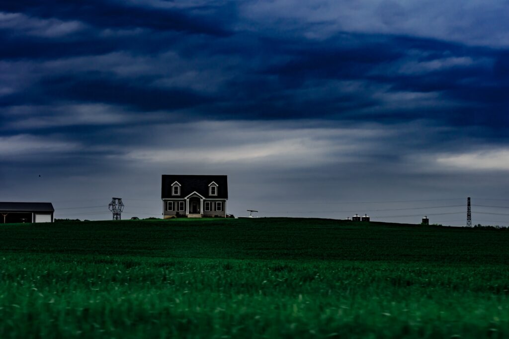 A small house under a stormy blue, gray sky.