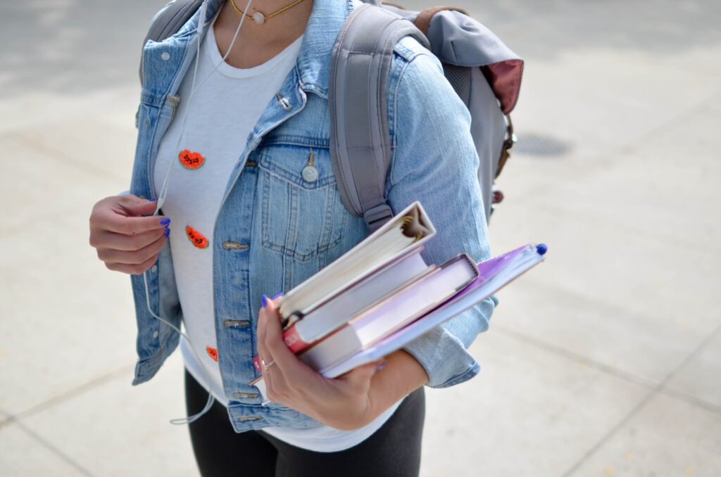 Close up of college student carrying books to school