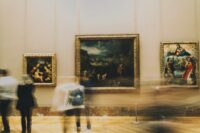 People observe art in a museum gallery.