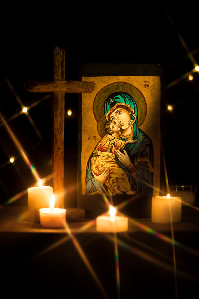 Icon of Virgin Mary holding Infant Jesus on altar with candles
