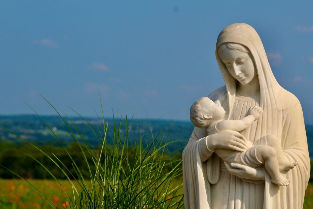An outdoor statute of the blessed mother holding the infant Jesus