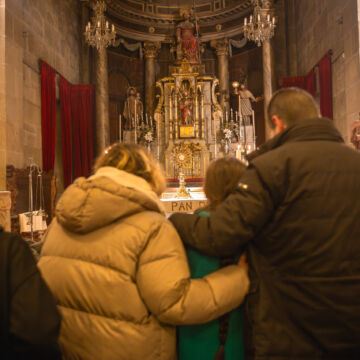 Family kneeling before an alter in Church praying before the Eucharist